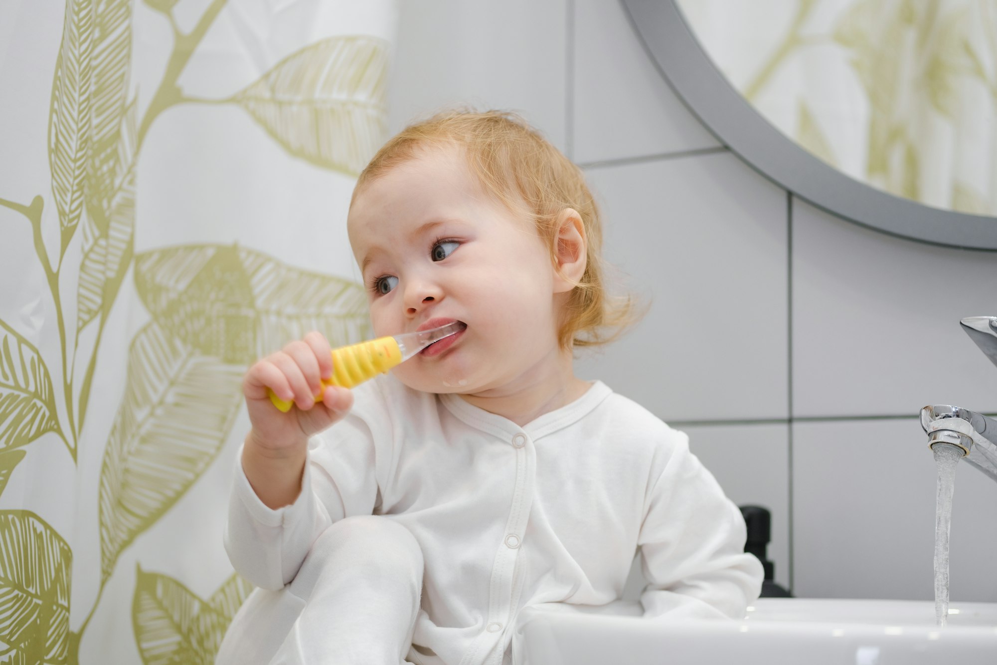 Kids personal hygiene. A toddler brushing teeth in bathroom. Teaching children morning routine.