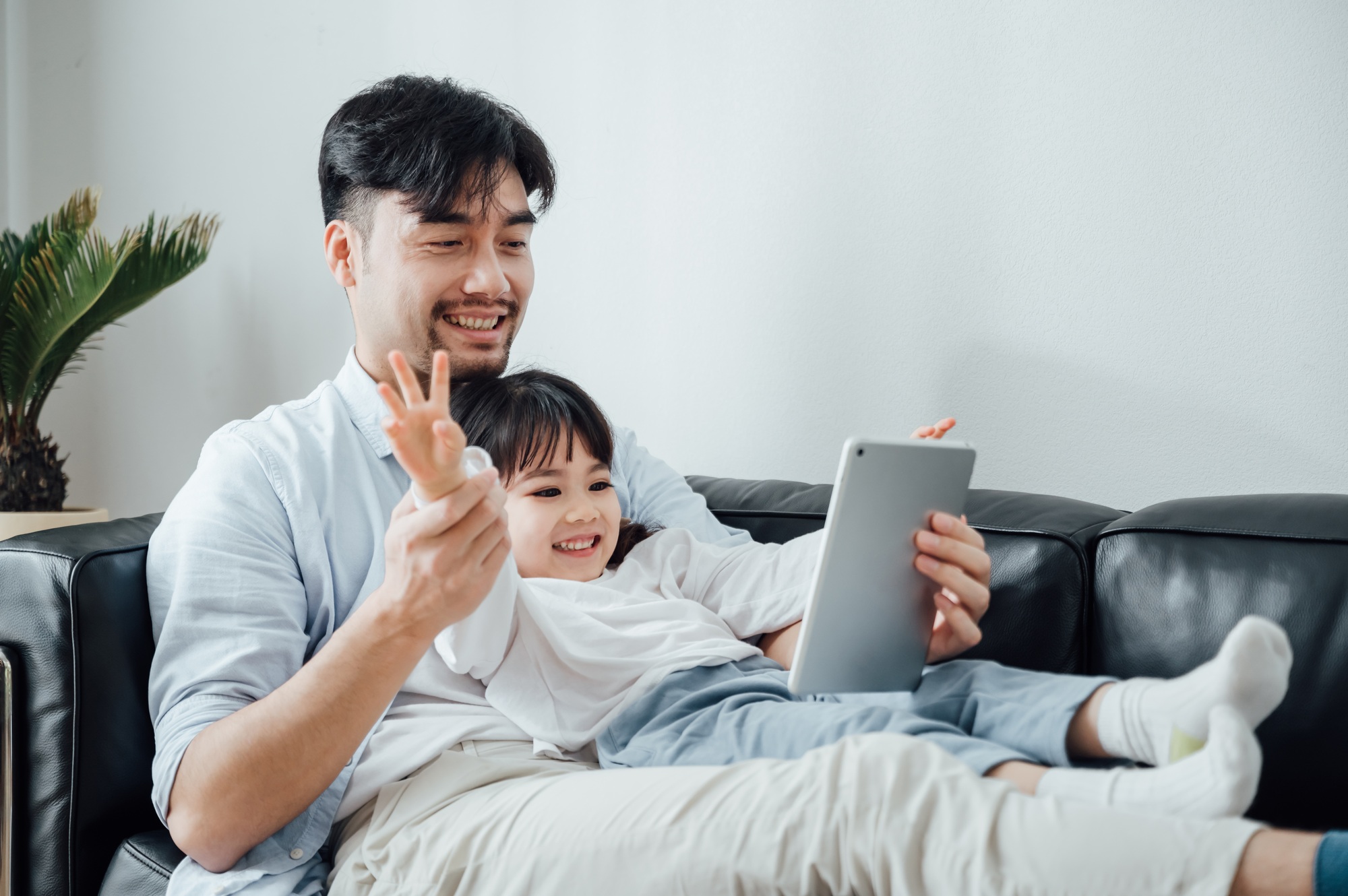 Father and daughter using ipad together at home