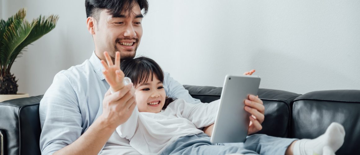 Father and daughter using ipad together at home