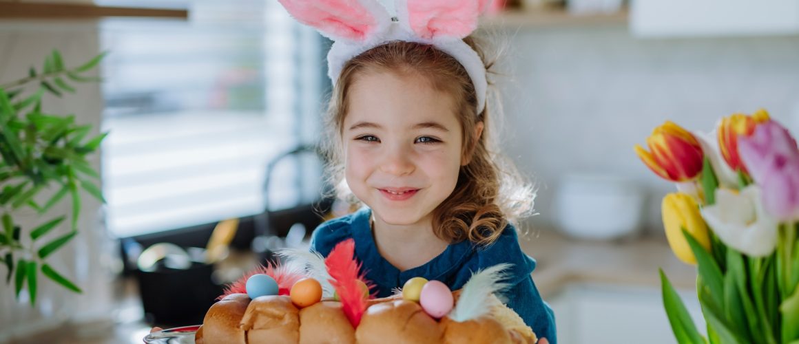 Little girl holding easter pastries, celebrating easter and spring.