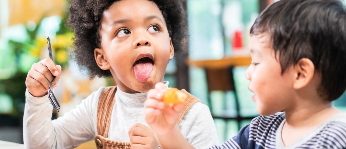 playful kids eating snack in cafe restaurant