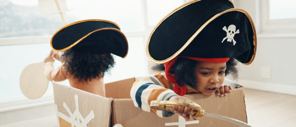 Playing, box ship and pirate children role play, fantasy imagine or pretend in cardboard container.