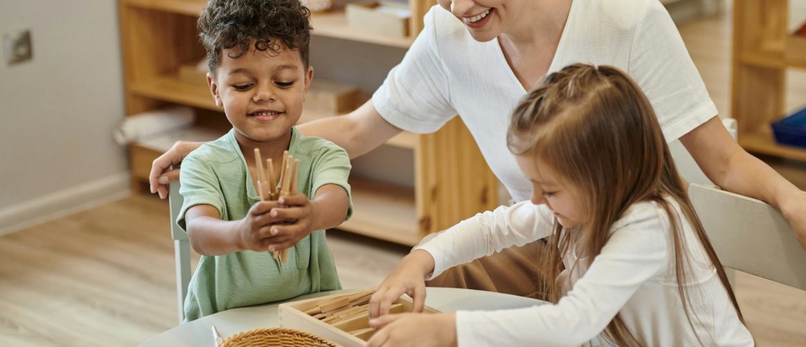 positive multiethnic kids playing with wooden didactic materials near teacher in montessori school